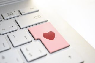 Computer keyboard with heart on large key. 
